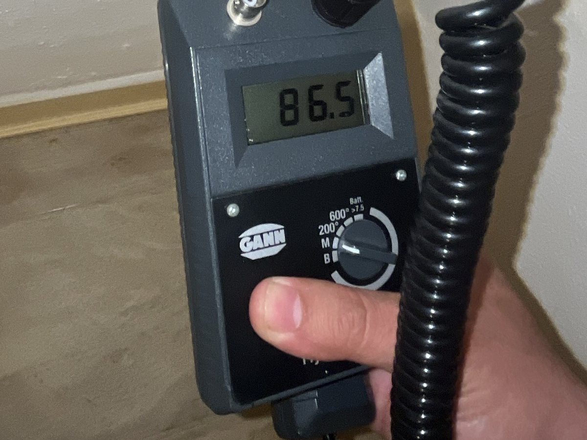 Feuchtemessung an einem Wandanschluss während einer Bauwerksprüfung